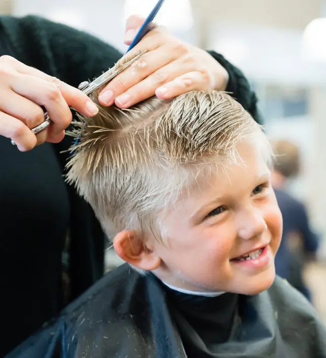 Young boy getting a haircut at barbershop.